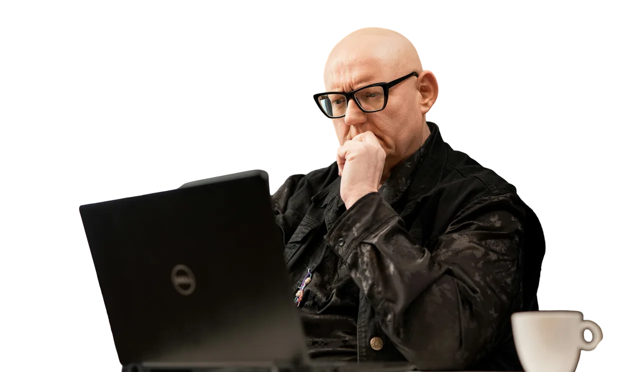 Bold man working on computer, wearing glasses